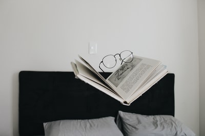 眼镜放在床上的书上面